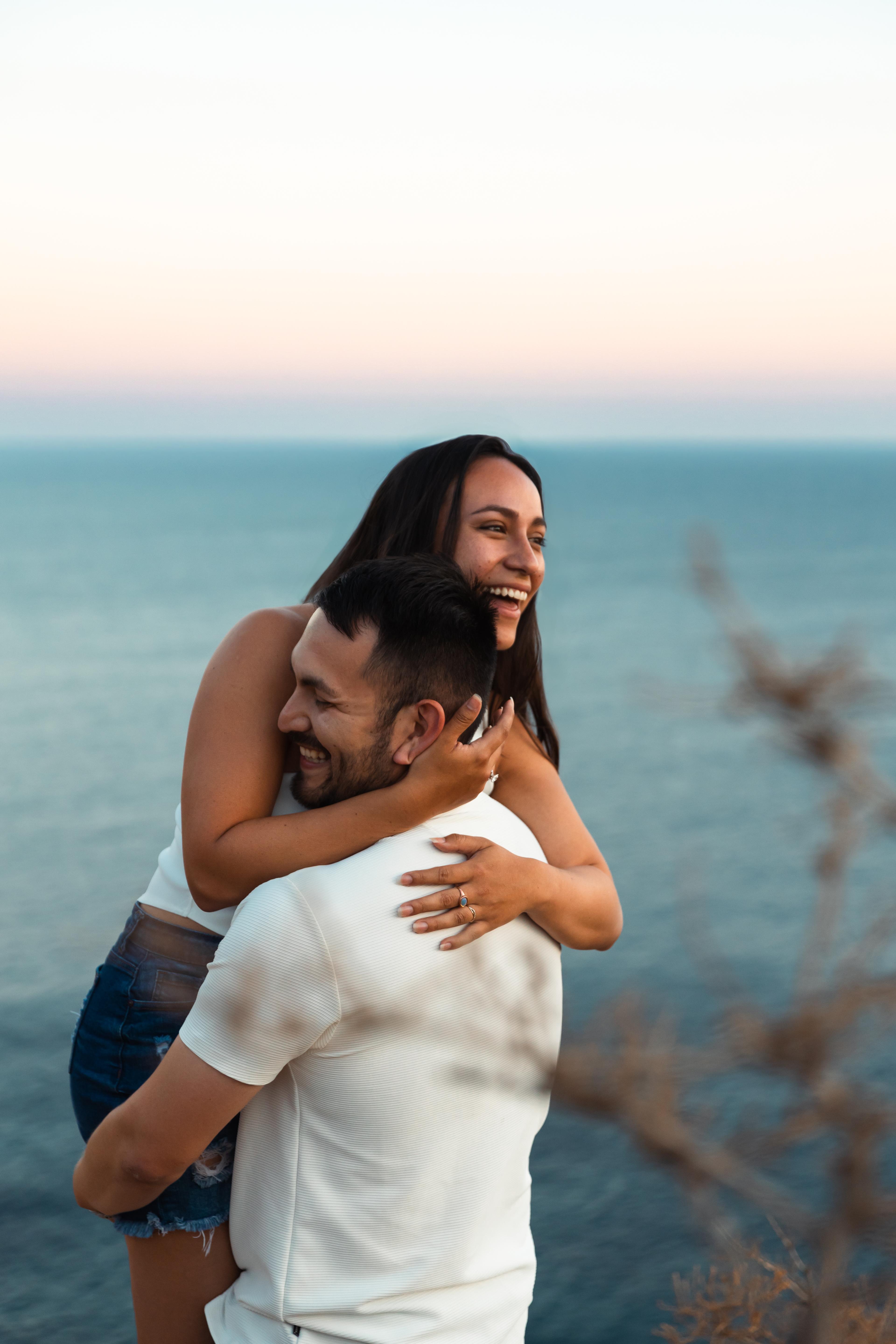 Alex lifting Angie, laughing together on the cliffs of Lima